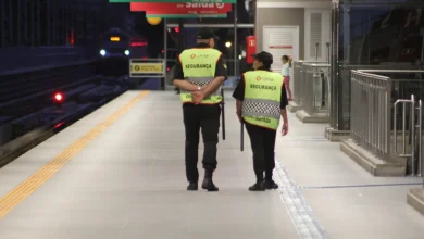 Vigilantes na CPTM patrulhando plataforma de estação para garantir segurança dos passageiros.
