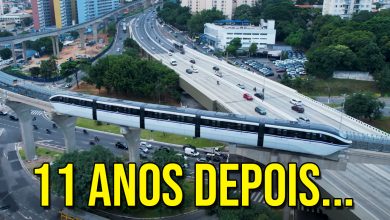 Trem do monotrilho da linha 17-ouro circulando em teste sobre trilhos elevados na Zona Sul de São Paulo, com trânsito urbano e vias expressas ao fundo.