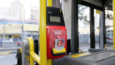 Validador do Bilhete Único dentro de um ônibus em São Paulo, destacando a funcionalidade de recarga no próprio veículo.