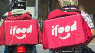 Dois entregadores iFood de moto com mochilas térmicas vermelhas nas costas, representando a rivalidade entre entregador iFood OL e Nuvem.