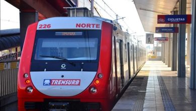 Trem da Trensurb estacionado na plataforma de uma estação em Porto Alegre, com destaque para a identidade visual vermelha e branca.