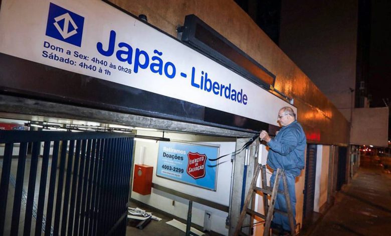 Funcionário retirando placa de nome da Estação Japão-Liberdade, que faz parte do Metrô de São Paulo.