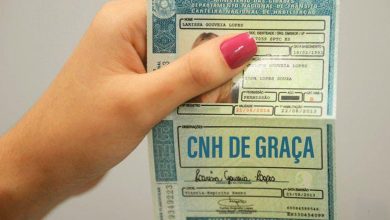 Pessoa segura CNH com destaque para inscrição 