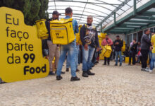 Entregadores reunidos com mochilas amarelas da 99Food durante evento de cadastro na 99Food.