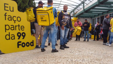 Entregadores reunidos com mochilas amarelas da 99Food durante evento de cadastro na 99Food.