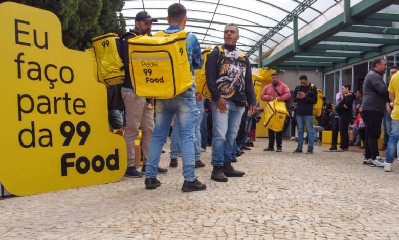 Entregadores reunidos com mochilas amarelas da 99Food durante evento de cadastro na 99Food.