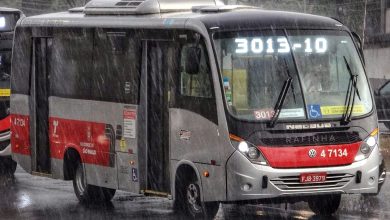 Ônibus da linha 3013/10 em dia chuvoso, com painel eletrônico visível.