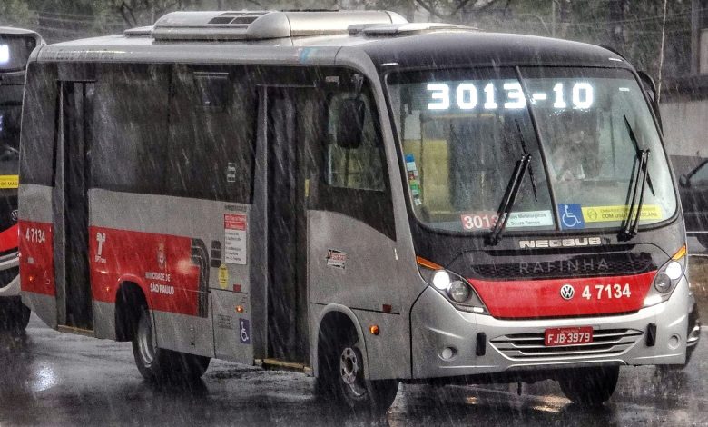 Ônibus da linha 3013/10 em dia chuvoso, com painel eletrônico visível.