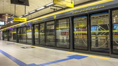 Estação de metrô com transporte sobre trilhos, mostrando plataforma e trem.