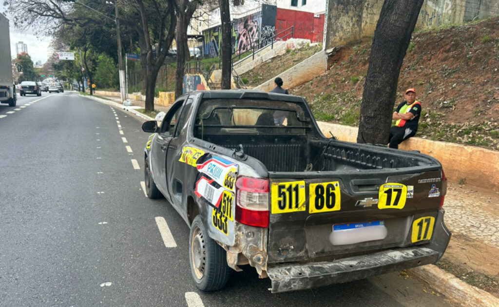 Picape Chevrolet Montana preta, com avarias e adesivos, apreendida por monitoramento inteligente de trânsito em rua de São Paulo.


