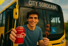 Passageiro de Sorocaba segurando Coca-Cola e churrasquinho grátis em frente ao ônibus expressos da cidade.