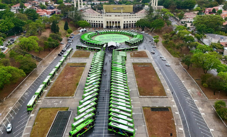 Vista aérea de novos ônibus elétricos estacionados em fileiras no Estádio do Pacaembu, em São Paulo.