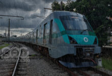 Trens da Linha 8-Diamante operando sob forte chuva em São Paulo, com o céu escuro ao fundo.