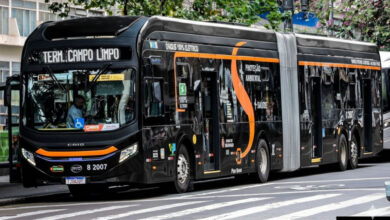 Ônibus elétrico articulado preto com detalhes laranja, simulando cores de ônibus São Paulo para o Term. Campo Limpo.