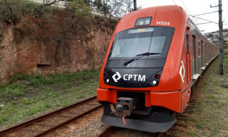 Trem da CPTM circulando na via férrea em meio à vegetação.