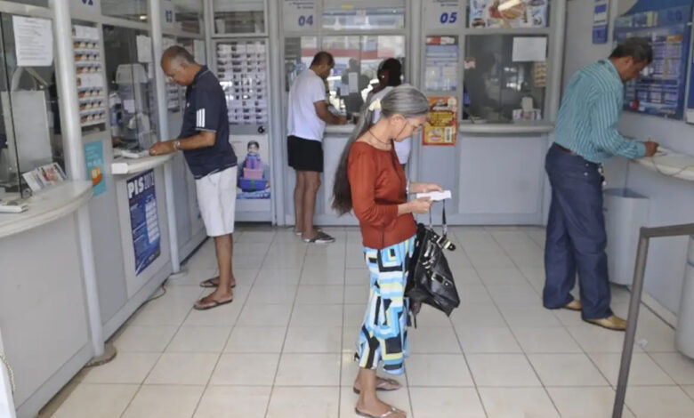 Interior de casa lotérica com clientes, local onde a recarga Bilhete Único lotérica pelo sistema da Caixa foi encerrada.